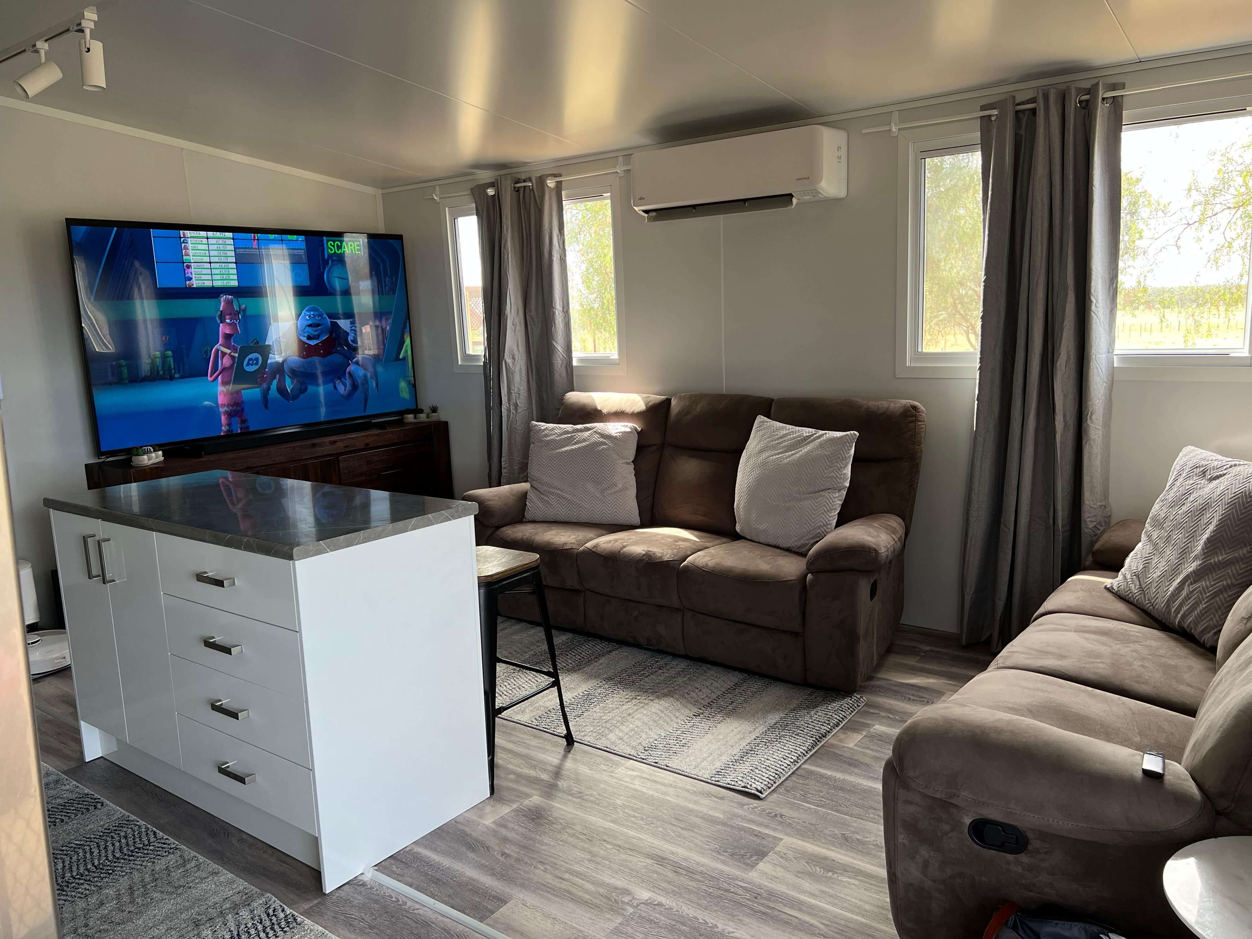 VanHomes - An open living area with plush sofas viewing the ktichen.