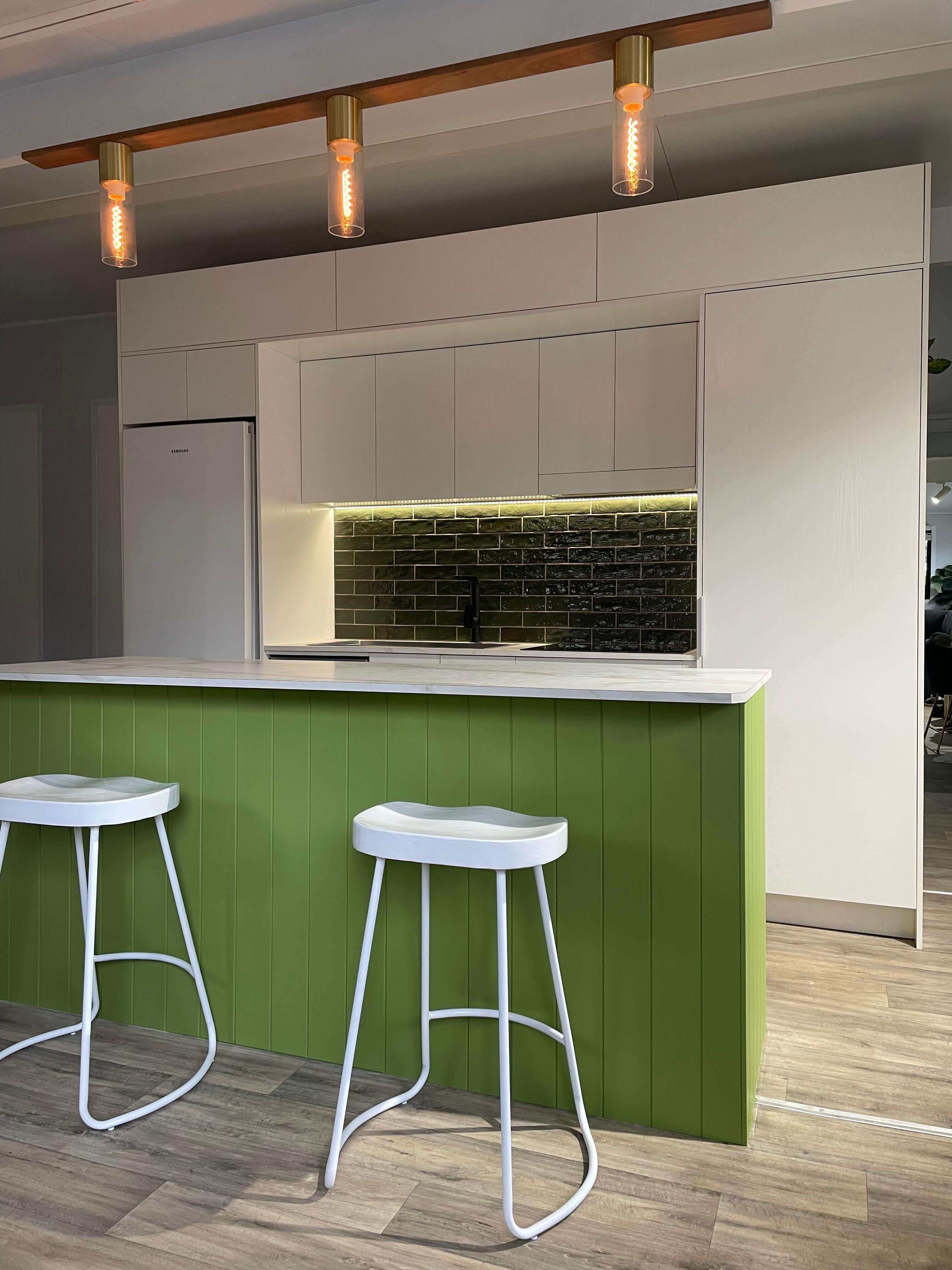 VanHomes - An open-concept kitchen with an island and bar stools.