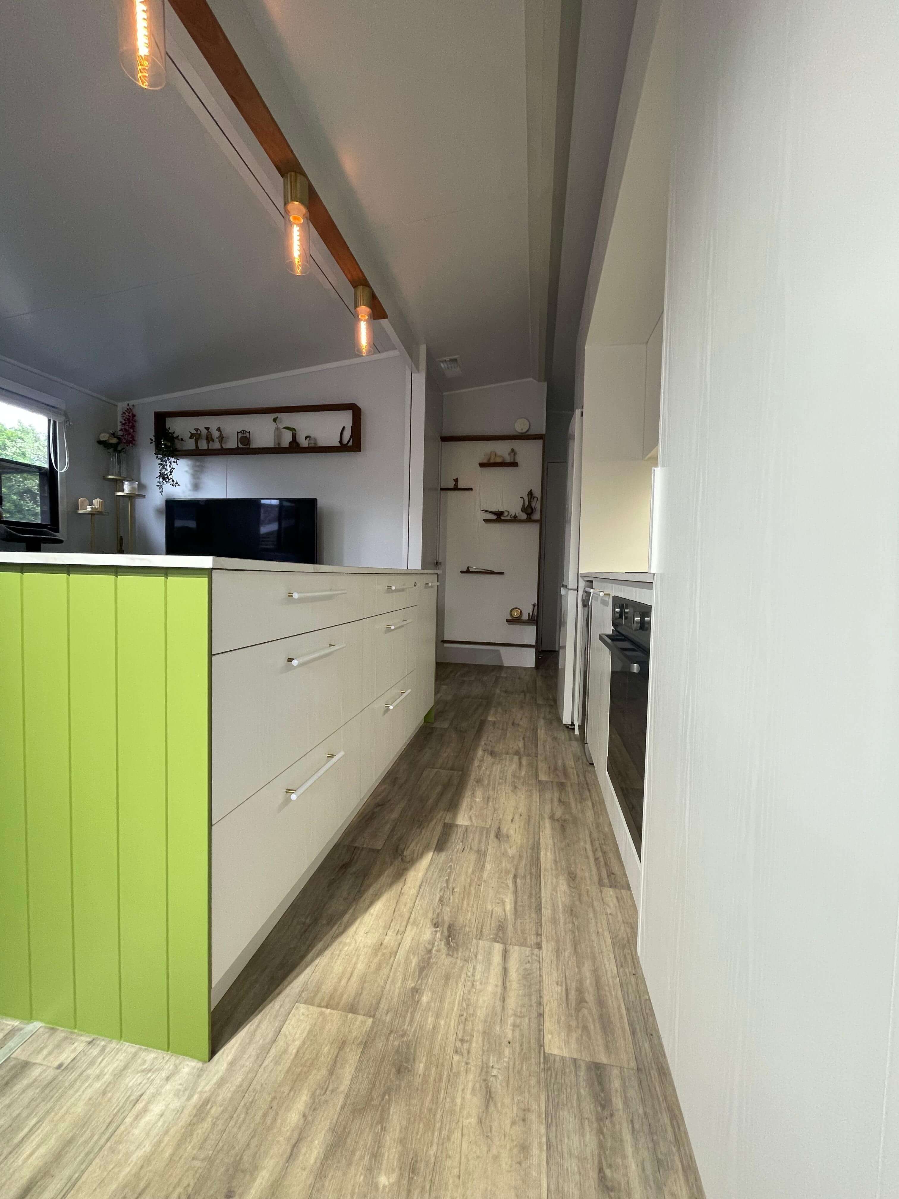 VanHomes - Modern kitchen with sleek white cabinets with a grass green finish