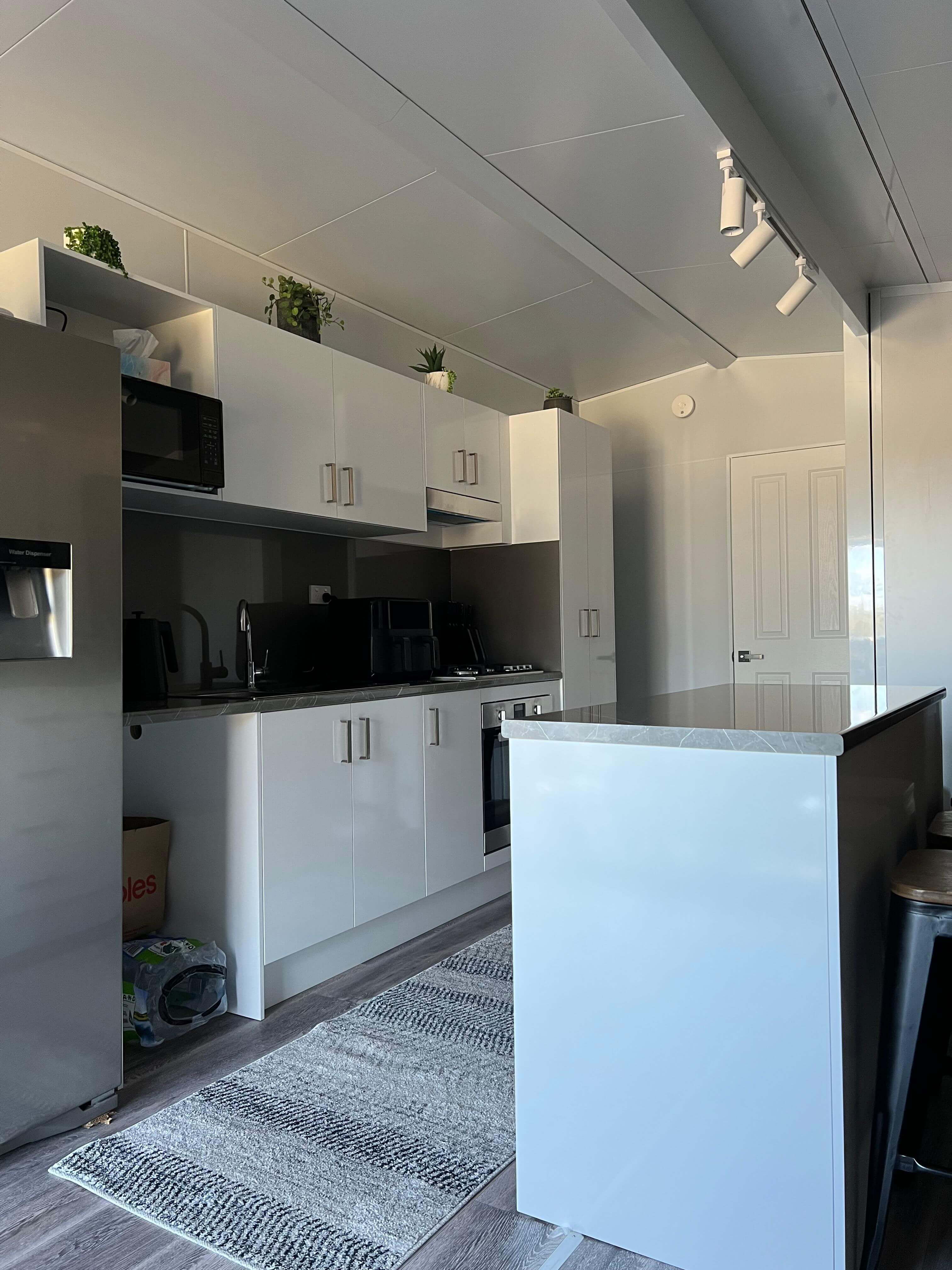 VanHomes - Modern kitchen with white cabinets and stainless steel appliances